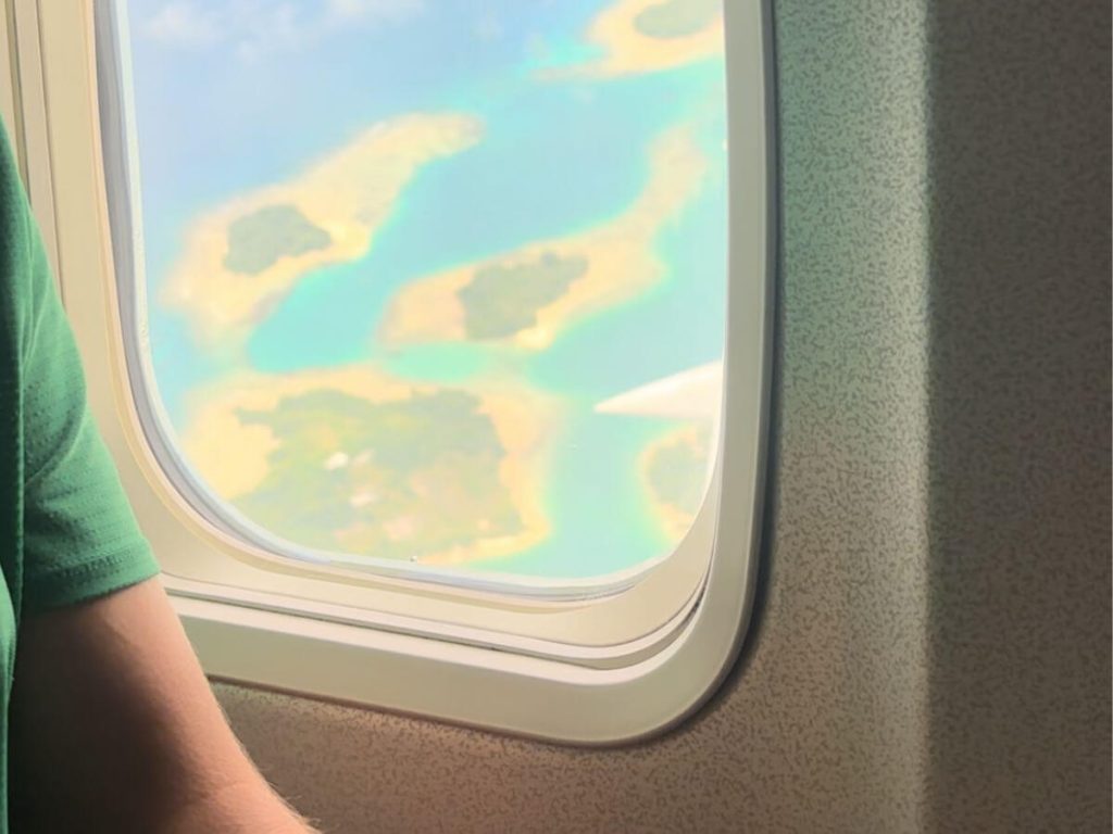 View of blue water and islands out of the window of a plane