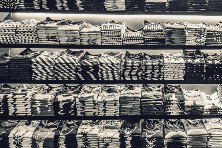 Stacks and stacks of black and white t-shirts neatly folded