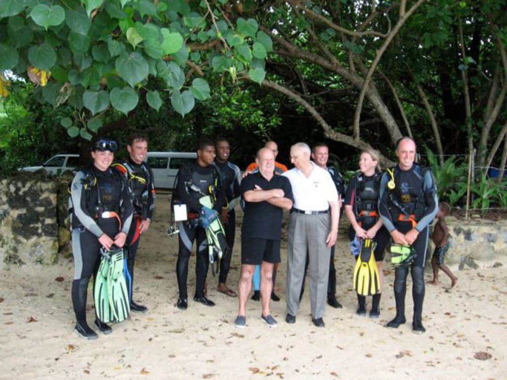 Allan Power standing with divers on the beach at the SS President Coolidge shore diving site