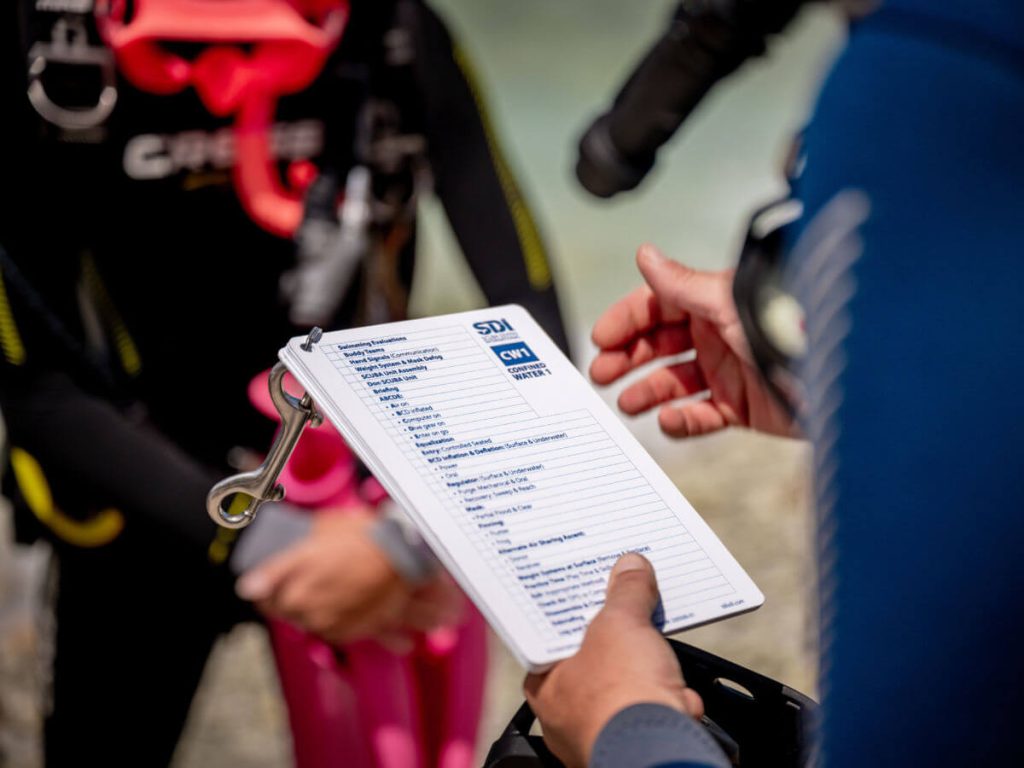 Scuba Diving Agencies SDI instructor teaching with slates