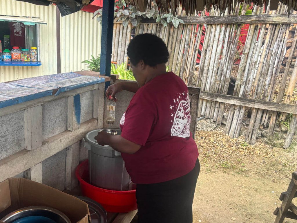 Drinking Kava in vanuatu, woman measuring out Kava into shells